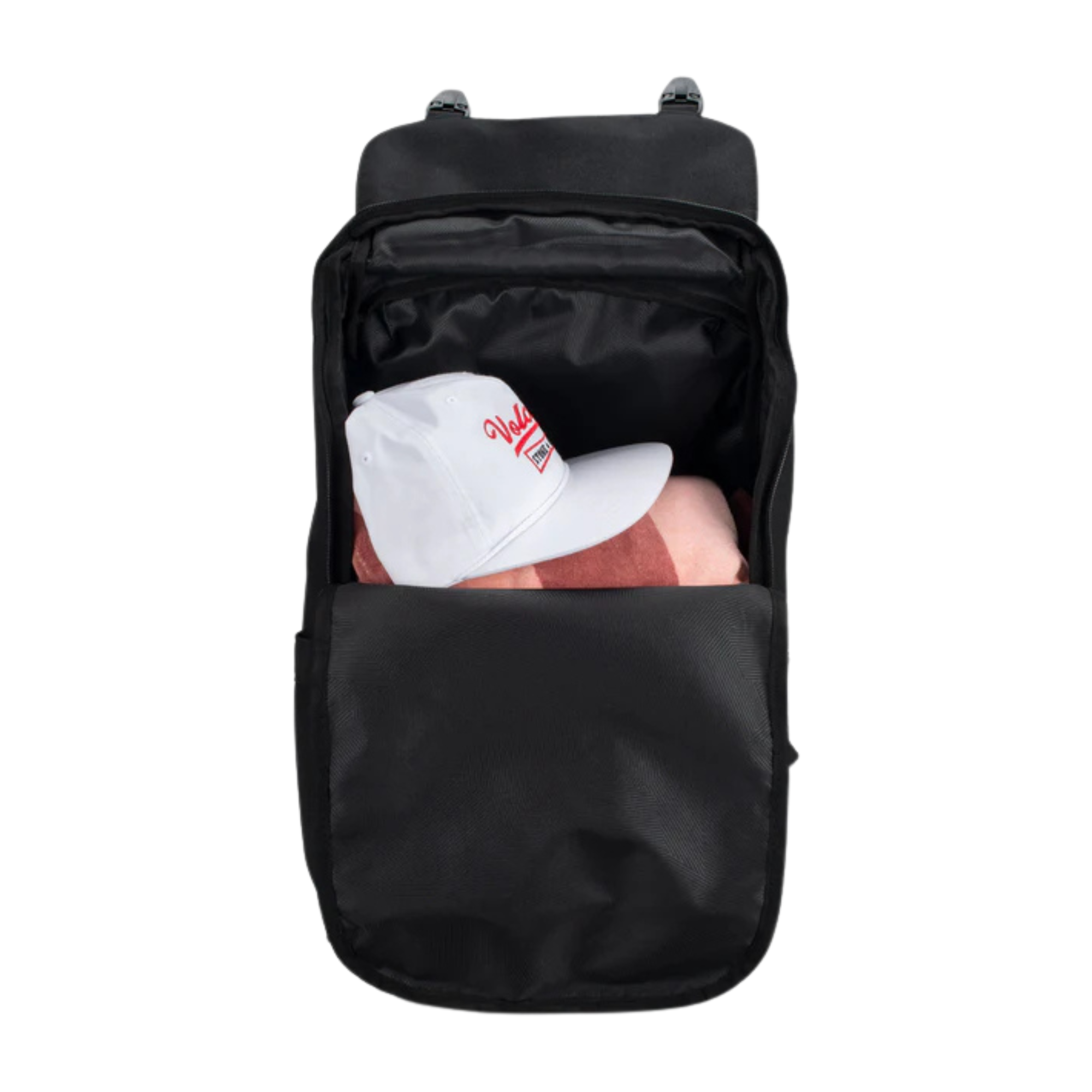 A black backpack shown from the front with its top zip compartment open, revealing a white baseball cap with red lettering and a pink item inside. The backpack is photographed on a solid white background.
