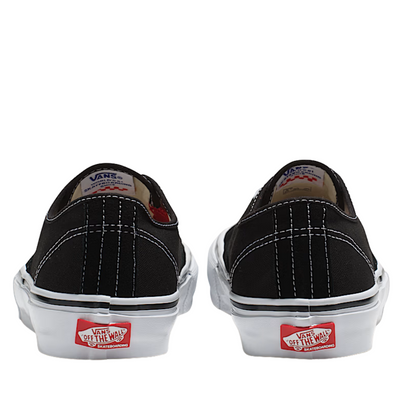 Black Vans shoes with red and white labels on a white background