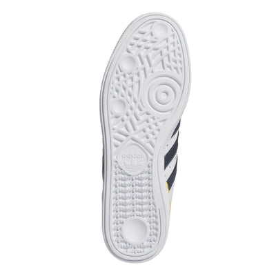 White adidas busenitz pro skateboard sneaker with navy stripes and yellow accent on a white background