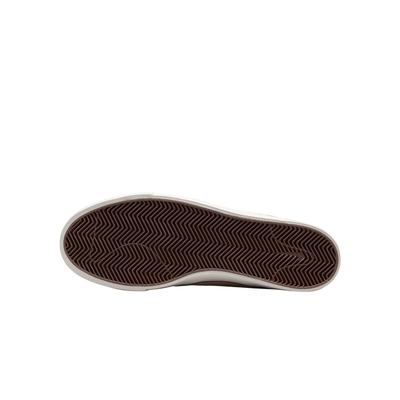 A Nike sb janoski low-top sneaker in a light beige suede and canvas mix, featuring a dark brown Swoosh logo, matching brown laces, and a thick white rubber sole.