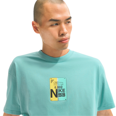 Man wearing a light blue t-shirt with a Nike logo on a white background