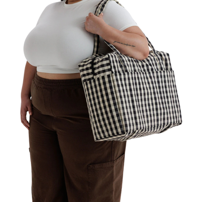 A black and white gingham checkered baggu cloud carry on tote bag with two shoulder straps, shown against a plain white background.