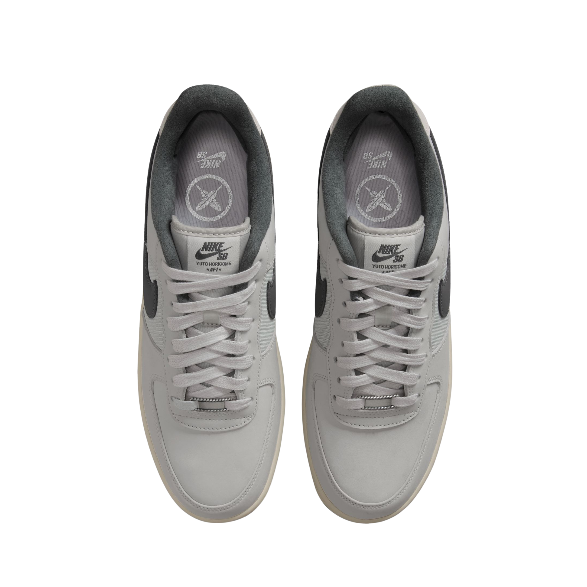 Nike sb x Yuto Air Force 1 Low skateboard sneakers in light gray and dark gray, featuring a light gray leather upper, dark gray Swoosh, and a cream midsole with a black outsole from above