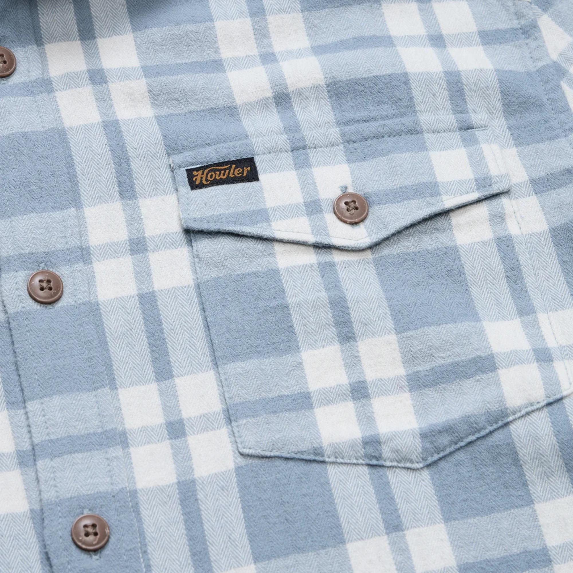 A light blue and white plaid howler brothers la grange lightweight flannel long-sleeve button-up shirt with brown buttons, a chest pocket, and a visible brand label on the collar and chest pocket.