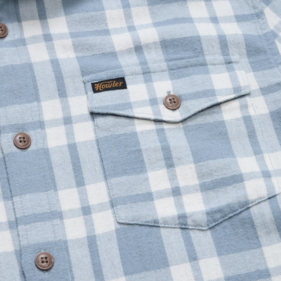 A light blue and white plaid howler brothers la grange lightweight flannel long-sleeve button-up shirt with brown buttons, a chest pocket, and a visible brand label on the collar and chest pocket.