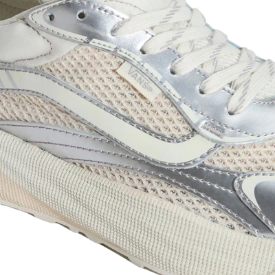 close up of a low-top vans ultrarange neo 2.0 sneaker shown in profile against a solid white background. The shoe features a cream-colored knit upper with metallic silver overlays, a chunky cream midsole, and white laces.
