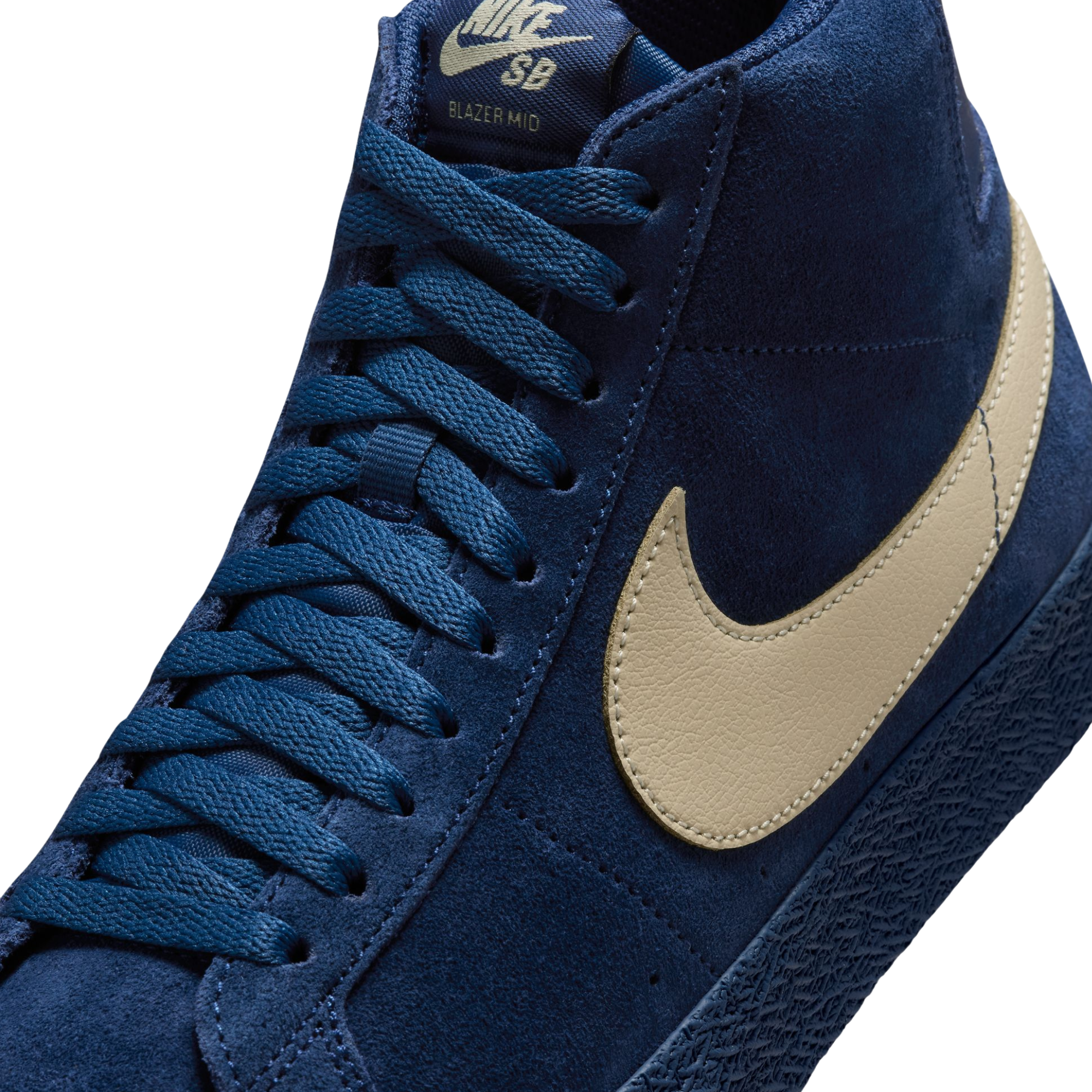 A high-top Nike sb Blazer skateboard sneaker in navy blue suede with a beige Swoosh logo and matching navy laces, shown from a side profile on a white background.