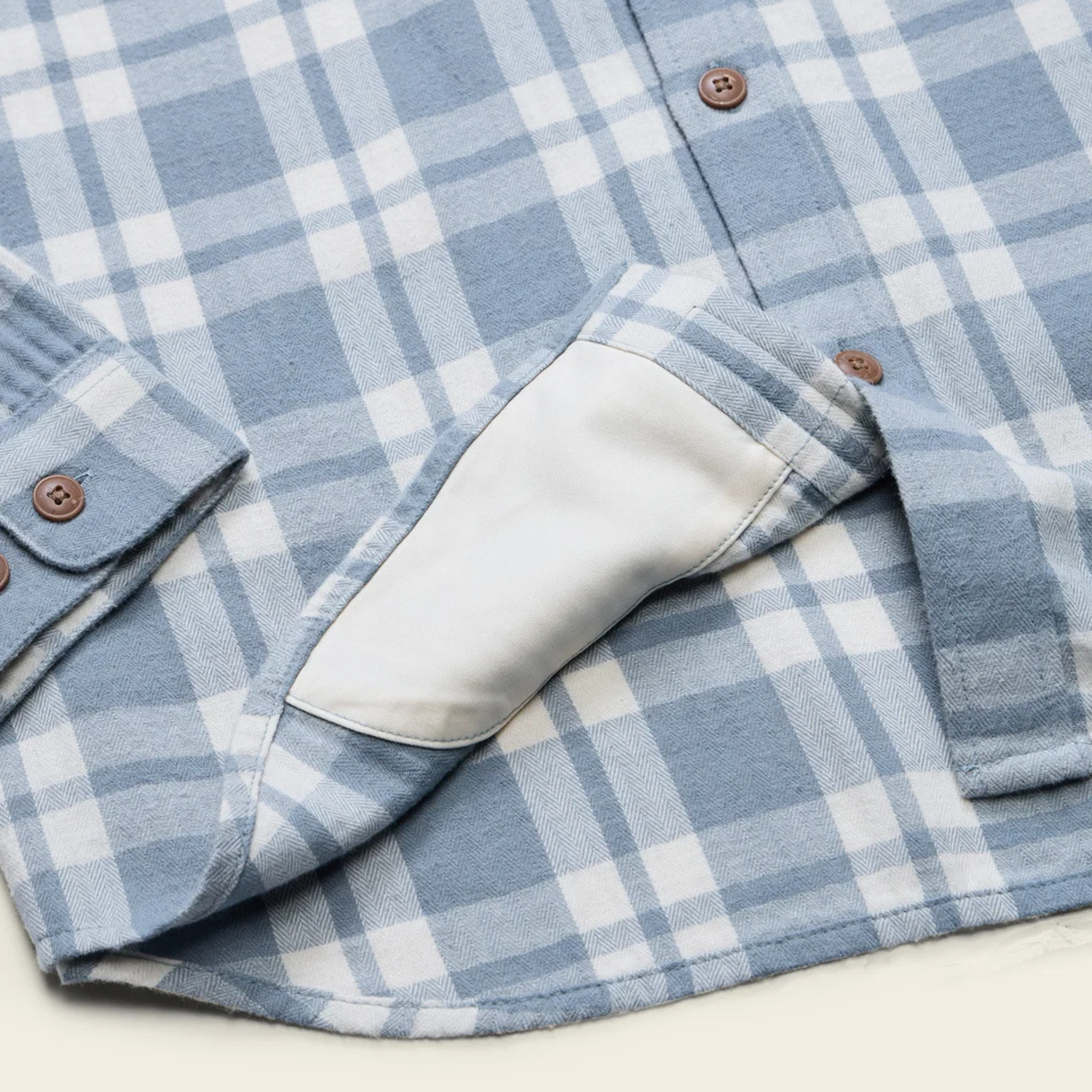A light blue and white plaid howler brothers la grange lightweight flannel long-sleeve button-up shirt with brown buttons, a chest pocket, and a visible brand label on the collar and chest pocket.