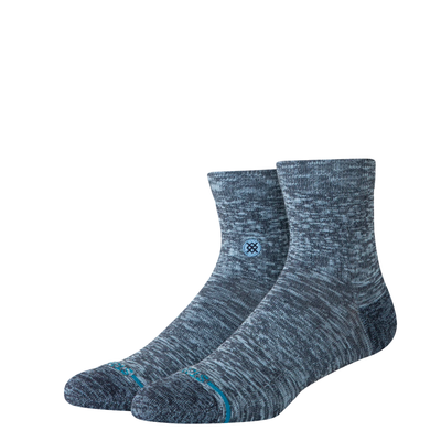 A pair of Stance slub quarter socks in a heathered slate blue and gray colorway, featuring a small blue logo on the side and a thin teal stripe near the toe, shown against a plain white background.