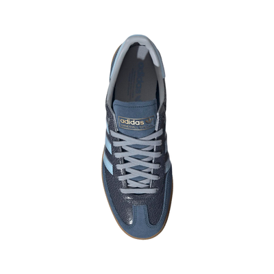 A single Adidas handball spezial sneaker in navy blue suede and textured leather, featuring light blue stripes, a light blue heel tab, and a brown gum sole, shown against a plain white background.
