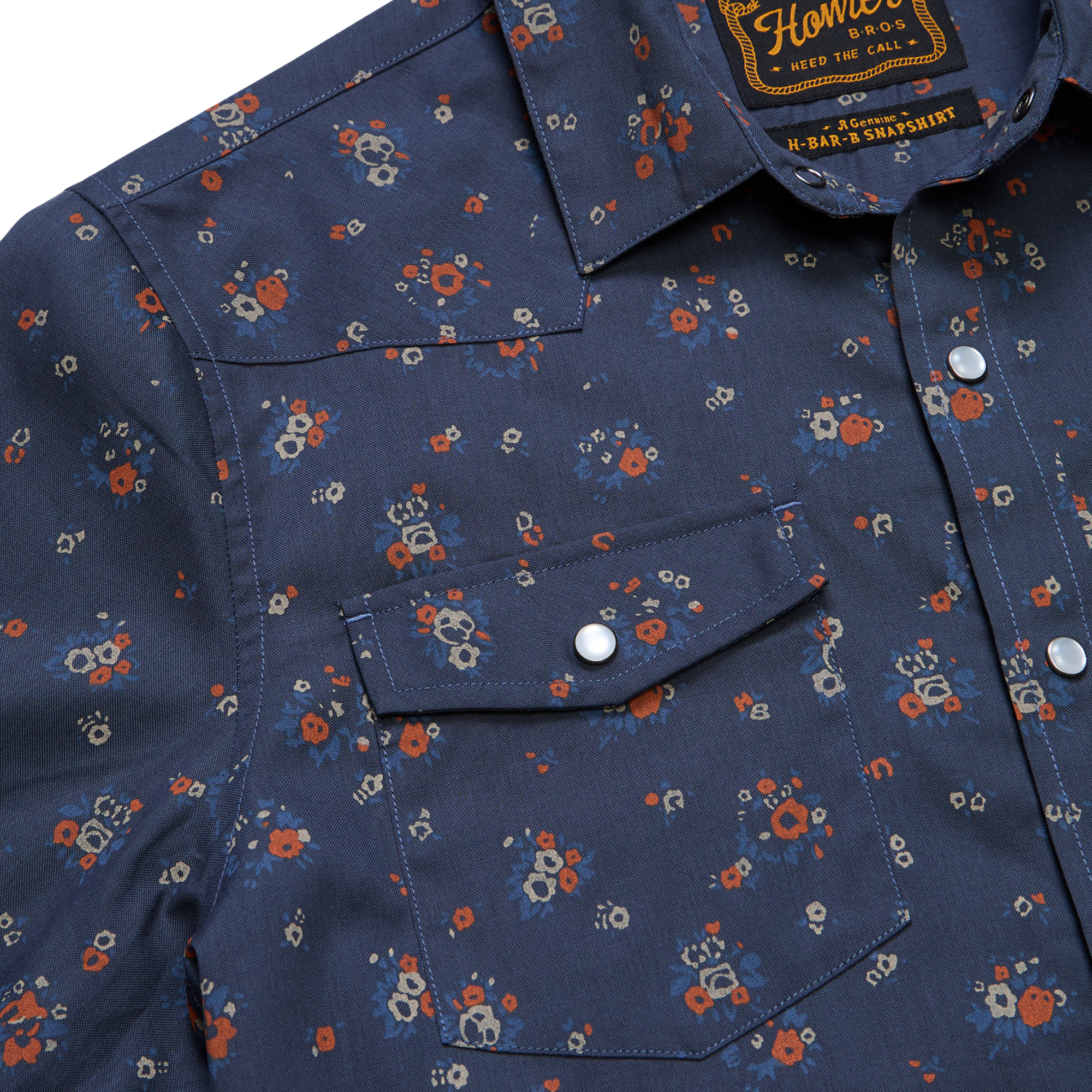 close up of a Holwer Brothers H Bar B Snapshirt Bouquets in a midnight blue wiht small all-over floral print on a white background