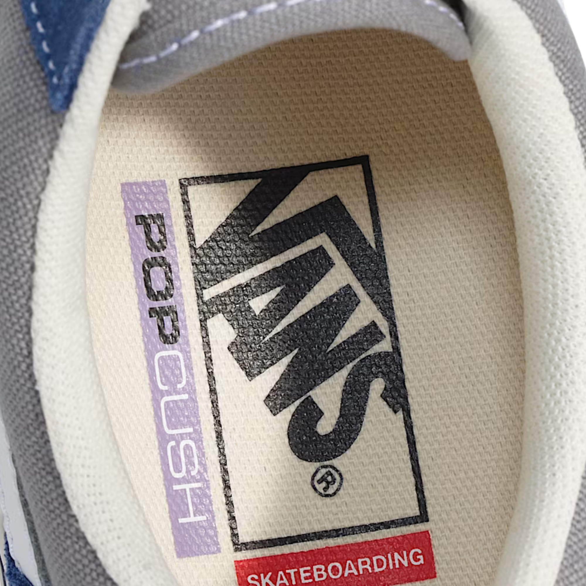 Close-up of a Vans logo on a shoe's tongue with 'Pop Cush' and 'Skateboarding' text.