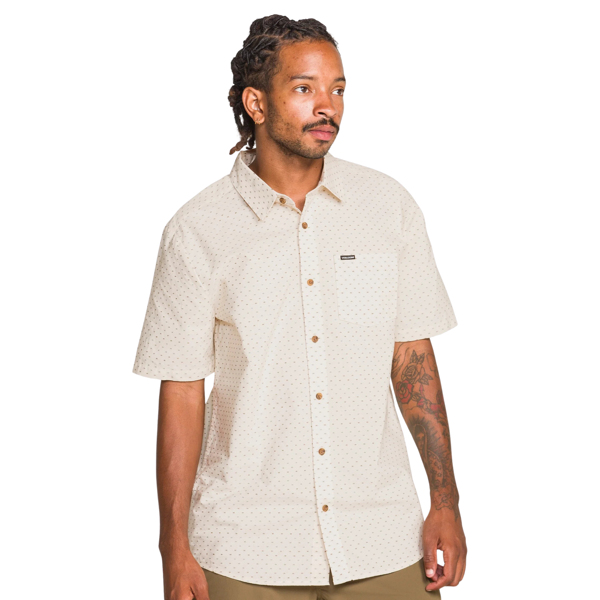 Man wearing a beige patterned volcom bankstone ii shirt on a white background