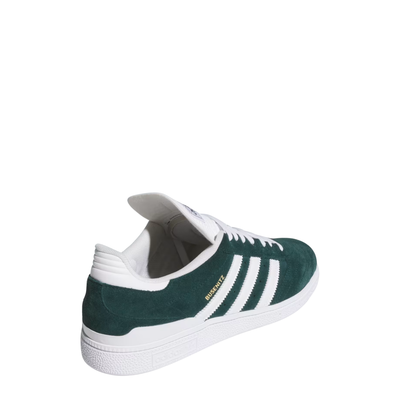 Green and white adidas busentiz skateboard sneaker with three white stripes on a light gray background