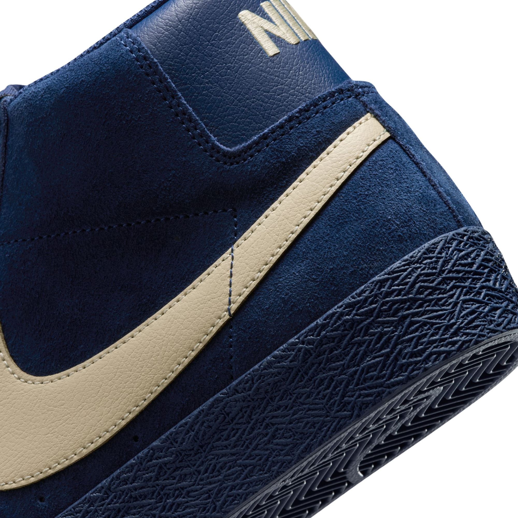 A high-top Nike sb Blazer skateboard sneaker in navy blue suede with a beige Swoosh logo and matching navy laces, shown from a side profile on a white background.