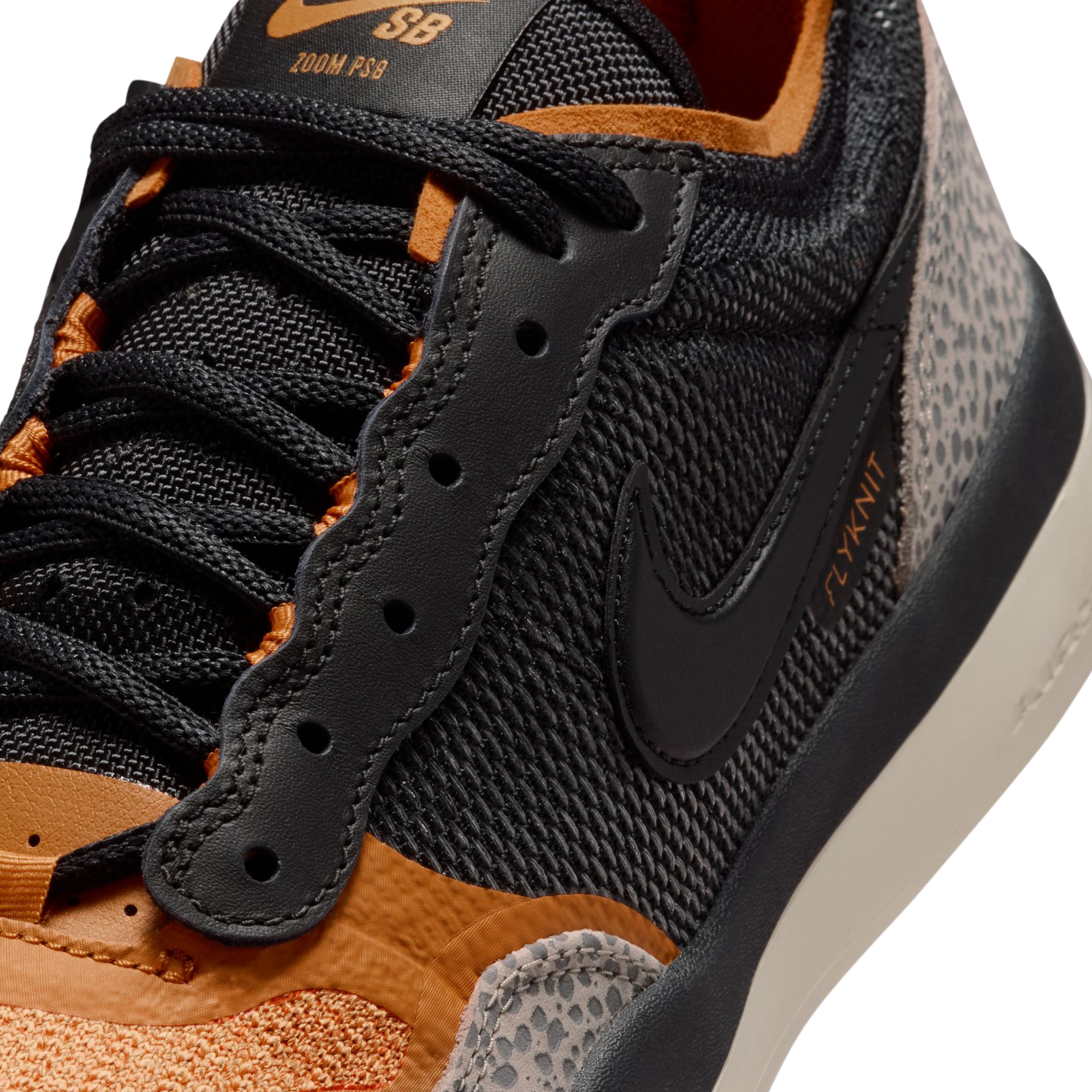 Close-up of A Nike SB PS8 skateboard sneaker in black, orange, and gray leopard print, showing the textured mesh upper, black Swoosh, orange accents, and a speckled gray and white heel section.