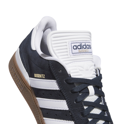 dark grey adidas busenitz skateboarding shoe with white strips and tongue and  gum sole on a white background