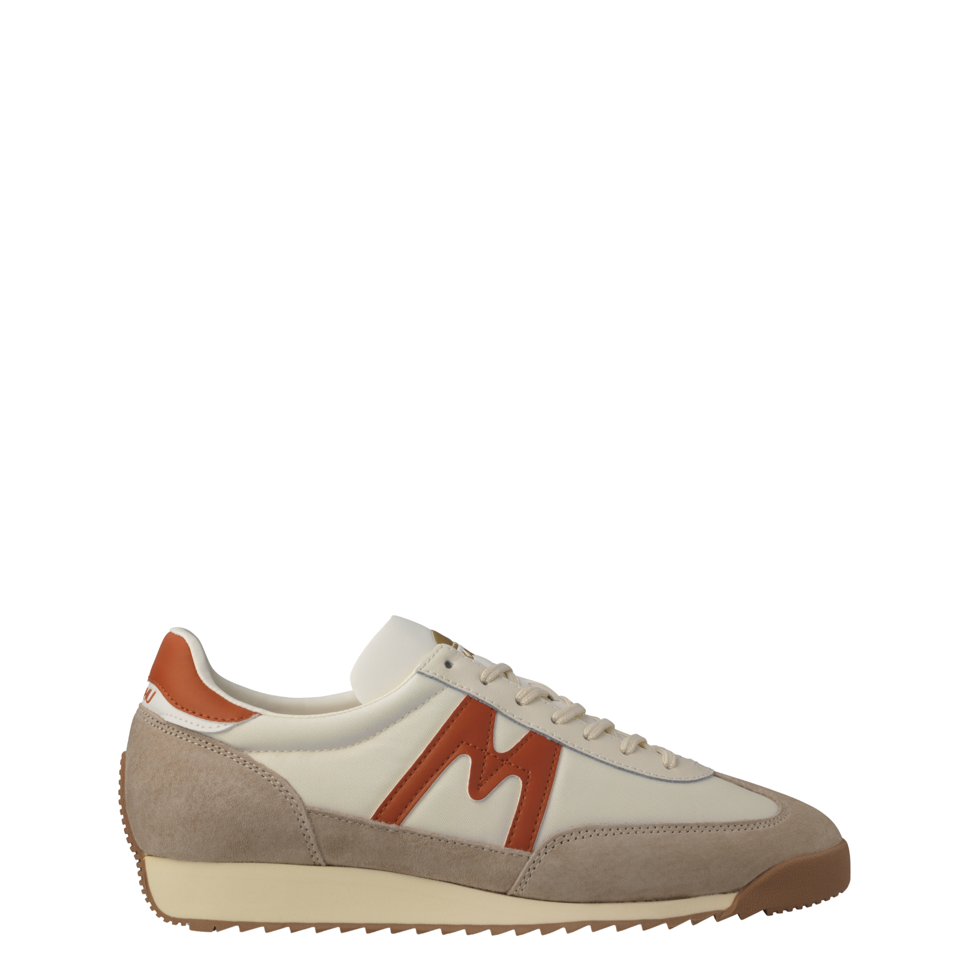 A low-top karhu mestari sneaker in beige suede and off-white leather with a prominent rust-orange 'M' logo on the side, a matching heel tab, and a beige midsole.