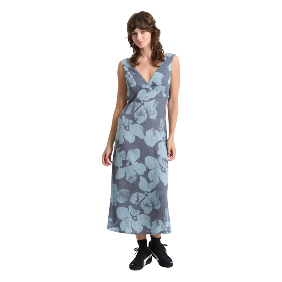 Woman wearing a sleeveless volcom grumpy sunshine floral dress on a white background
