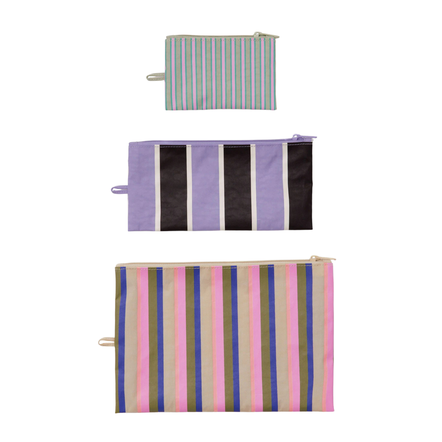 Three striped baggue flath zip pouches stacked vertically on a white background, each with a small fabric loop on the side. The top pouch has thin green, white, and blue stripes; the middle pouch has lavender, black, and white stripes; the bottom pouch has pink, blue, beige, and white stripes.