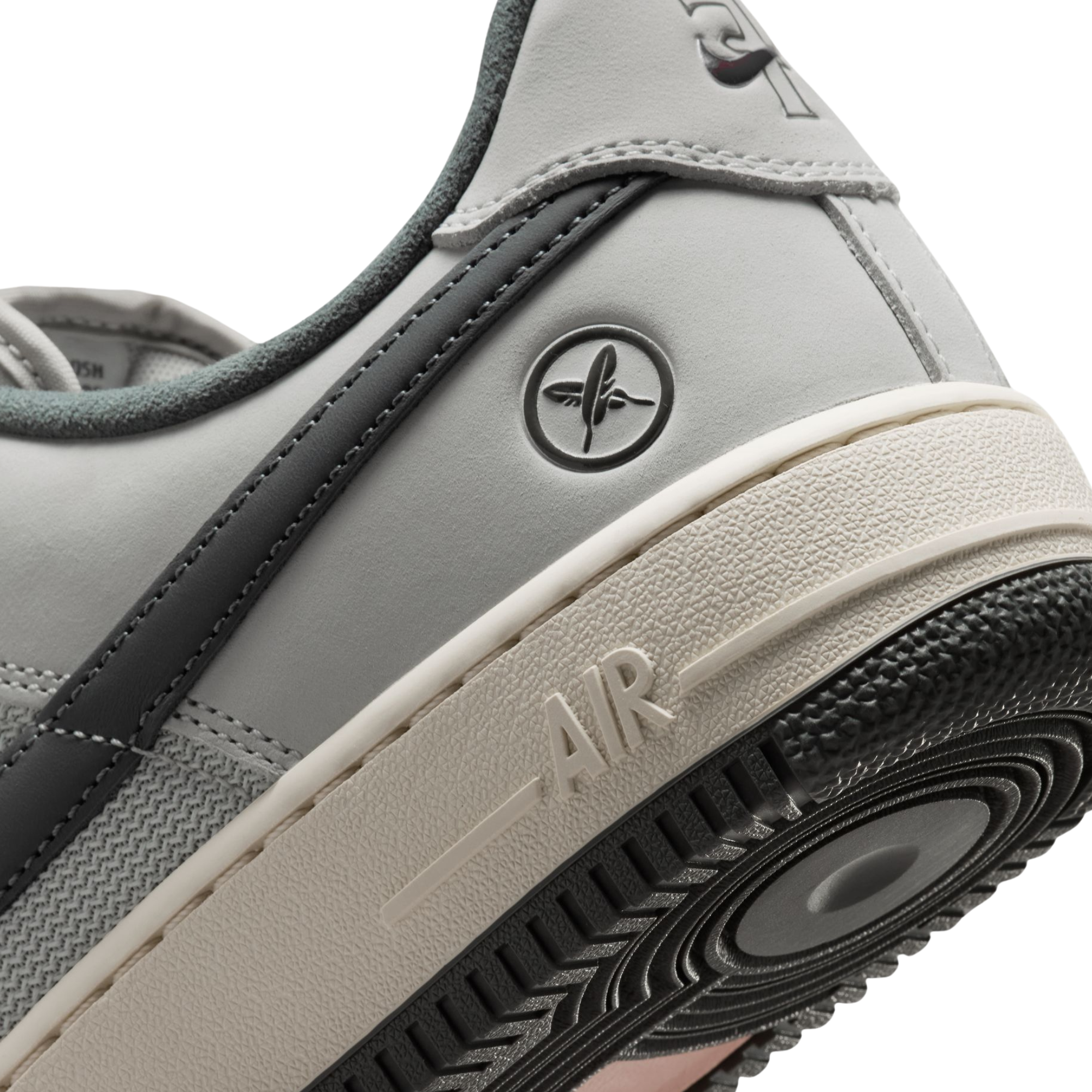 close up of the heel of a Nike sb x Yuto Air Force 1 Low skateboard sneakers in light gray and dark gray, featuring a light gray leather upper, dark gray Swoosh, and a cream midsole with a black outsole.