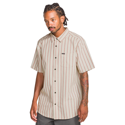Man wearing a beige and red striped volcom sato stripe short sleeve shirt on a white background
