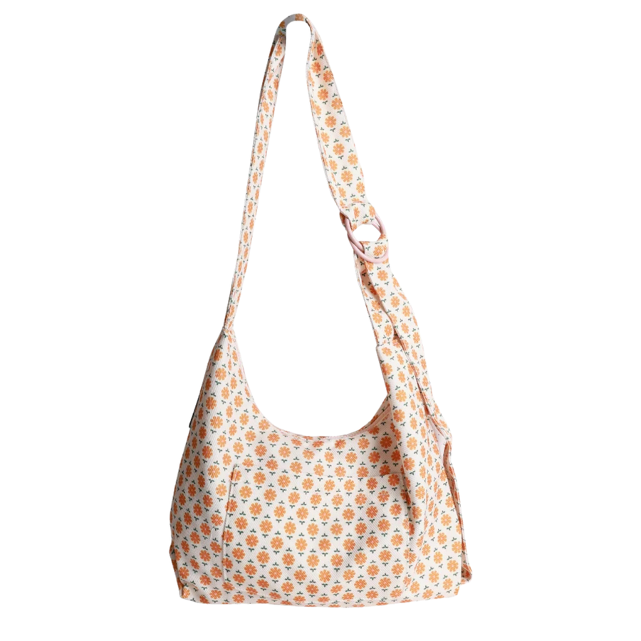 A slouchy thread shoulder bag with a white base and an all-over orange and yellow floral pattern, featuring a single adjustable shoulder strap.