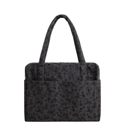 A black baggu cloud carry-on tote bag with a subtle tonal floral pattern, featuring two top handles and side pockets, shown against a plain white background.