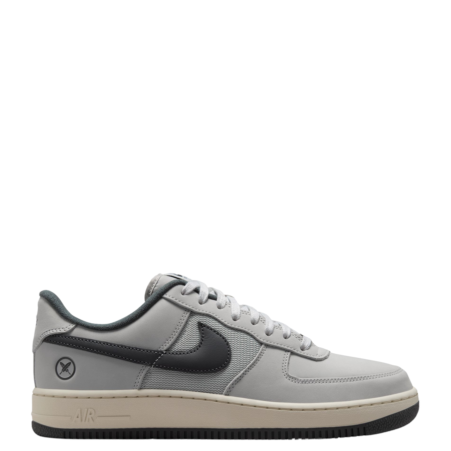 Nike sb x Yuto Air Force 1 Low skateboard sneakers in light gray and dark gray, featuring a light gray leather upper, dark gray Swoosh, and a cream midsole with a black outsole.