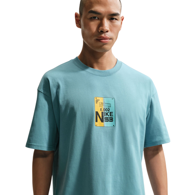 Man wearing a light blue t-shirt with a Nike logo on a white background