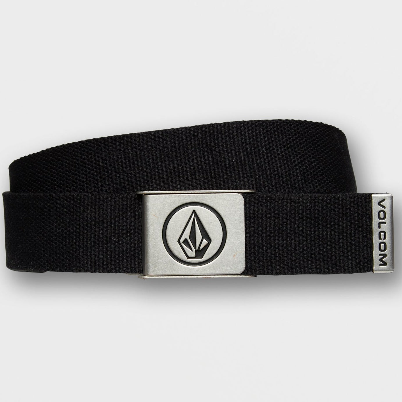 An black volcom circle woven web belt with a silver metal buckle featuring a circular black logo, coiled on a plain white background.
