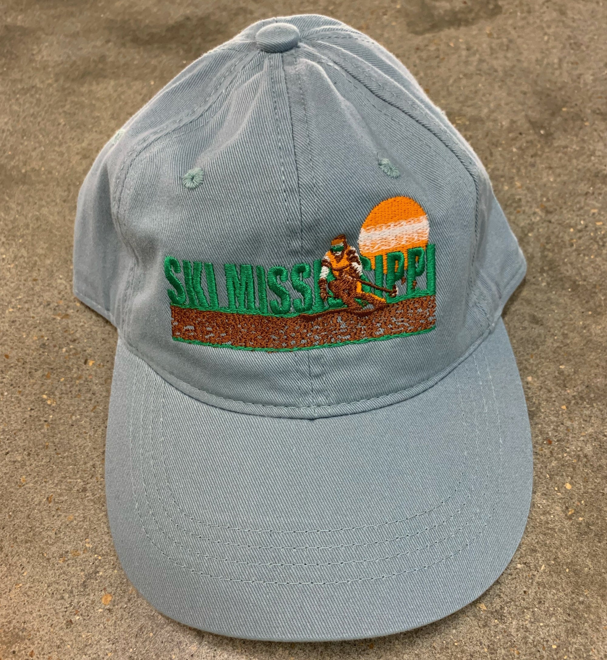 blue embroidered hat featuring the ski mississippi logo in green brown and orange