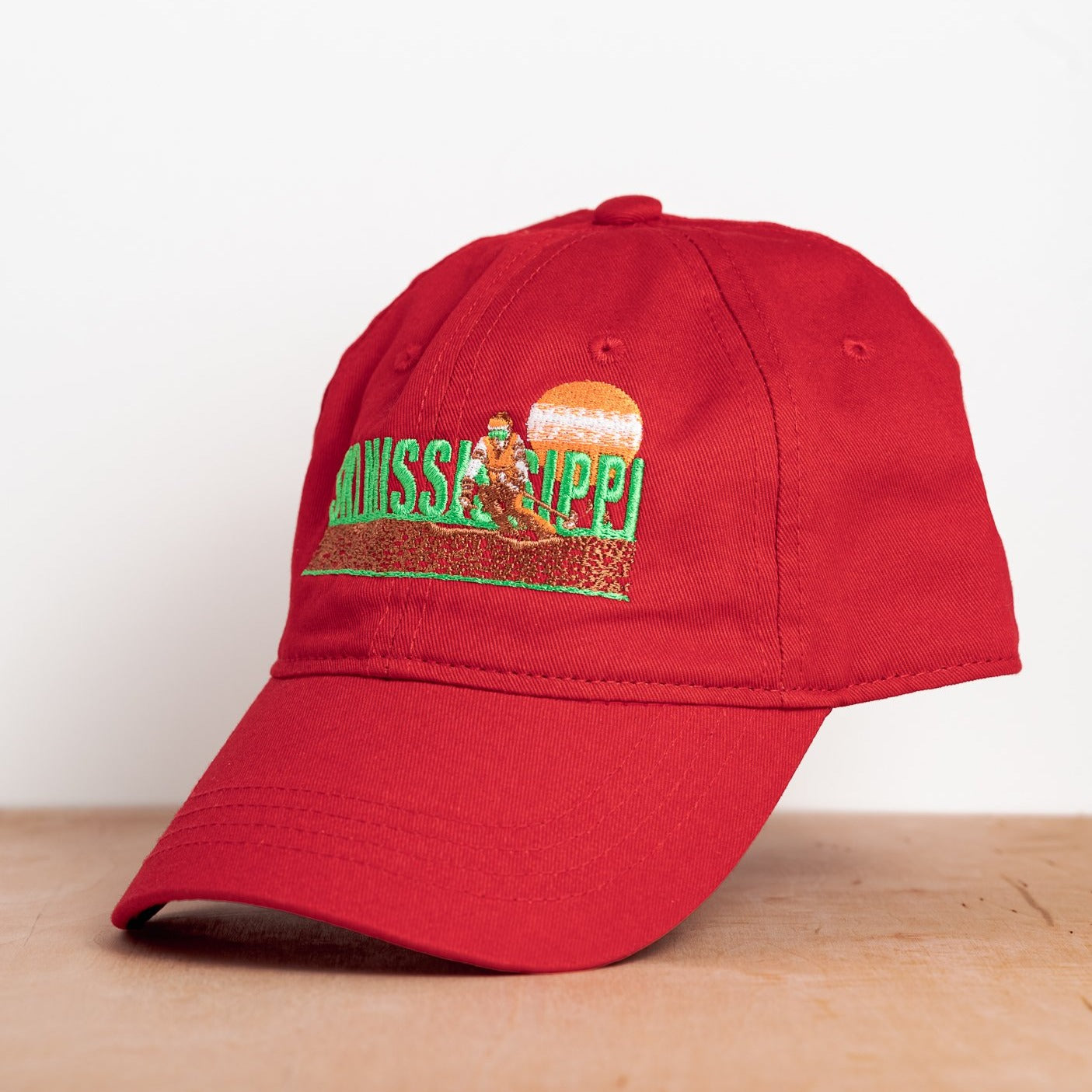 red embroidered hat featuring the ski mississippi logo in green brown and orange