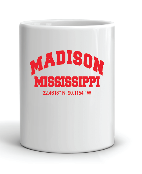 A white mug that reads "Madison Mississippi 32.4618 N, 90.1154 W" in red.