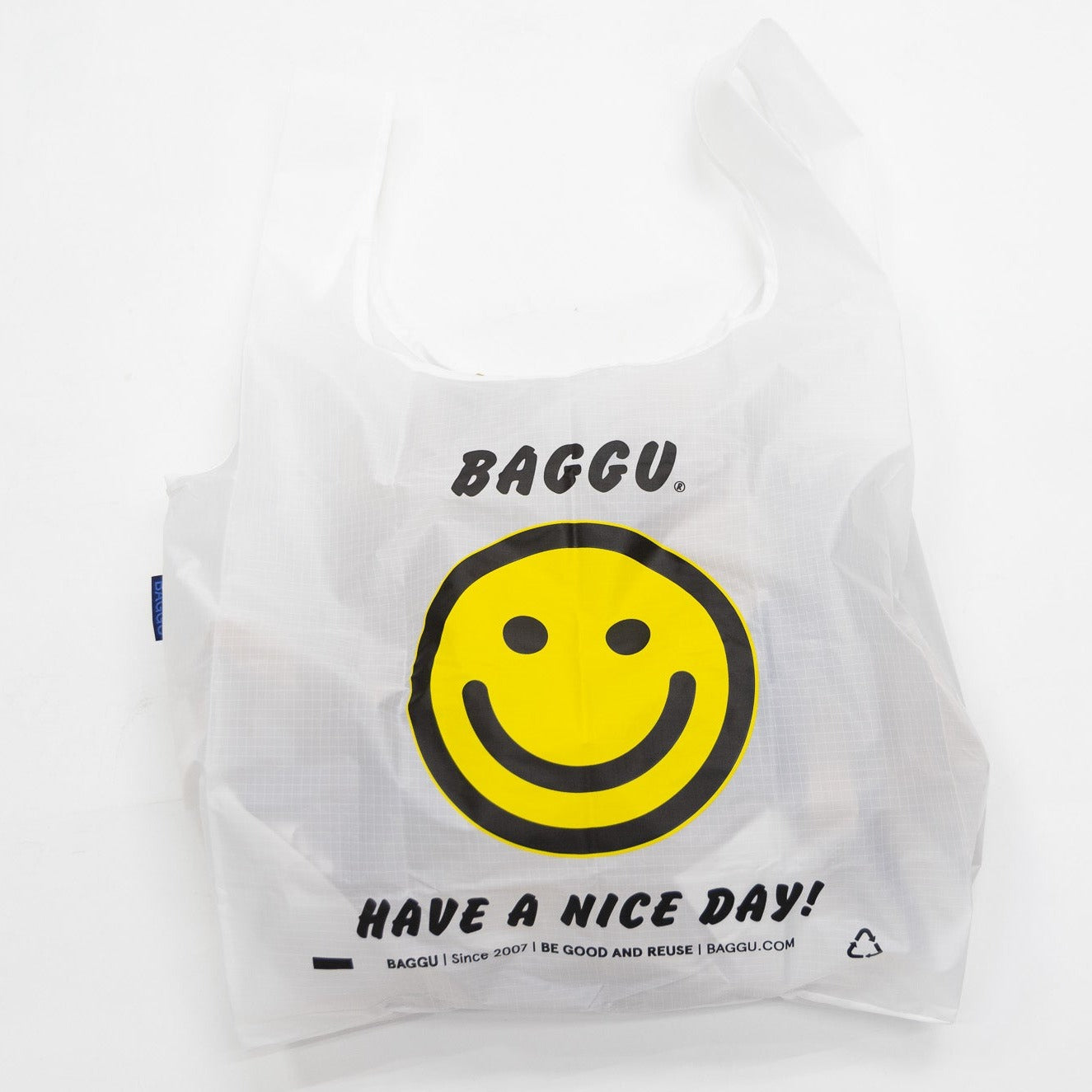 white Baggu Standard Reusable tote Bag with yellow smiley face